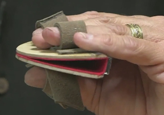 Hand holding puppet mouthplate in a neutral position